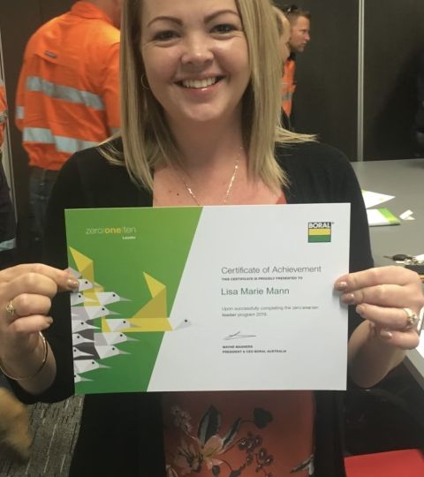 Lisa-Marie Mann standing with a certificate of achievement