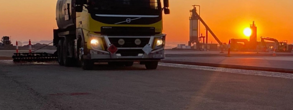 Hot Spray Seal machine on asphalt pavement with sunset in background