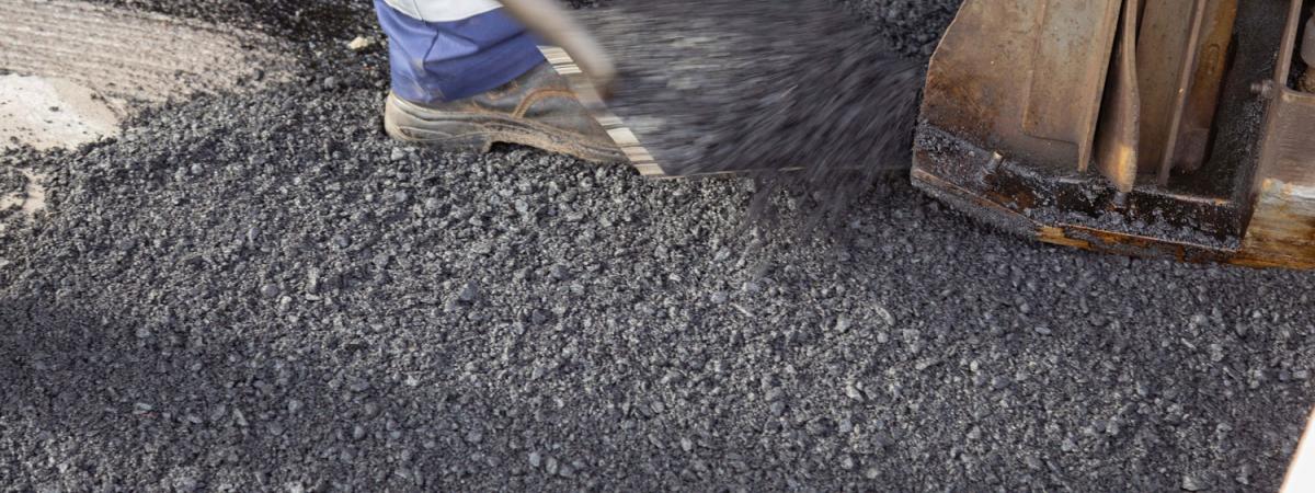 Recycled asphalt pavement being laid by worker