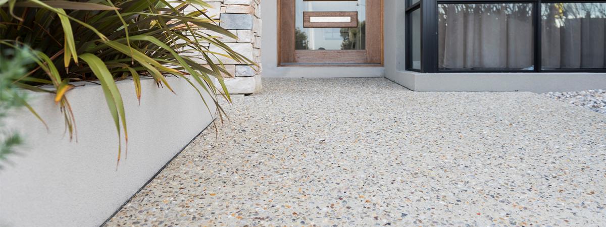 Exposed aggregate concrete in light beige colour leading to front door of house