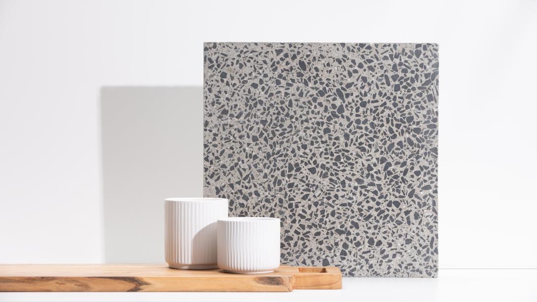 Slab of boralstone concrete in the colour Galaxy next to two white pots