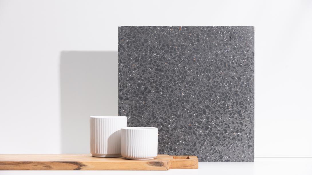 Slab of boralstone concrete in the colour Midnight next to a wooden chopping board with white ramekins