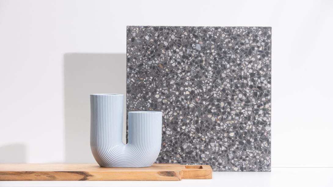 Slab of boralstone concrete in the colour Nightscape next to a pale blue home decor piece